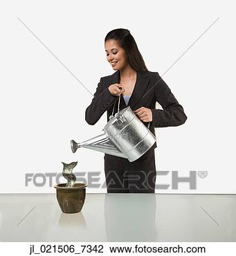 Stock Photo - studio shot of 
woman watering 
pot with money 
growing in it. 
fotosearch - search 
stock photos, 
pictures, images, 
and photo clipart