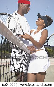 Stock Photo - young couple holding 
tennis rackets 
standing on a 
tennis court. 
fotosearch - search 
stock photos, 
pictures, images, 
and photo clipart