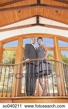 Stock Photography - young couple standing 
on a balcony looking 
down. fotosearch 
- search stock 
photos, pictures, 
images, and photo 
clipart