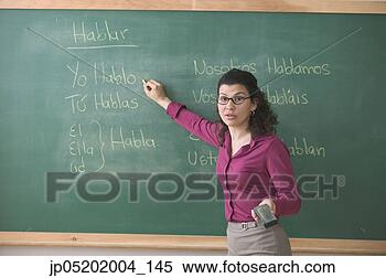 Stock Image - portrait of mid 
adult female teacher 
writing on a chalkboard. 
fotosearch - search 
stock photos, 
pictures, images, 
and photo clipart