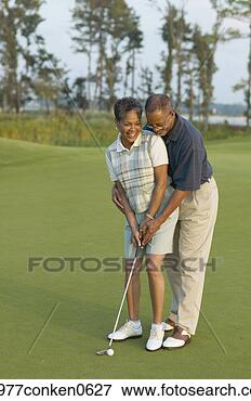 Picture - mature man teaching 
a mature woman 
how to play golf. 
fotosearch - search 
stock photos, 
pictures, images, 
and photo clipart