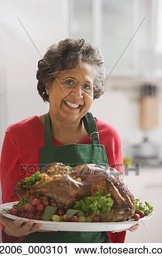 Stock Photography - senior hispanic 
woman holding 
roasted turkey. 
fotosearch - search 
stock photos, 
pictures, images, 
and photo clipart