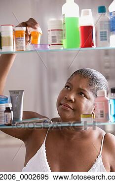 Stock Image - woman looking 
through medicine 
cabinet. fotosearch 
- search stock 
photos, pictures, 
images, and photo 
clipart