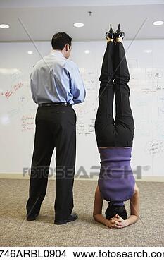 Stock Photo - businesswoman 
doing headstand 
next to businessman 
in front of. fotosearch 
- search stock 
photos, pictures, 
images, and photo 
clipart