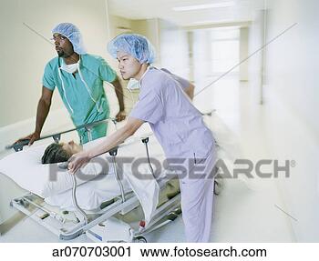 Stock Photography - medical professionals 
pushing a patient 
on a gurney in 
a hospital. fotosearch 
- search stock 
photos, pictures, 
images, and photo 
clipart