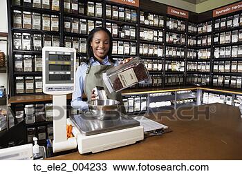 Stock Photo - african saleswoman 
weighing herbs 
on scale. fotosearch 
- search stock 
photos, pictures, 
images, and photo 
clipart