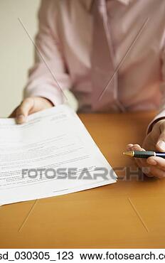 Stock Photo - mid section view 
of a businessman 
holding a pen 
and a document. 
fotosearch - search 
stock photos, 
pictures, images, 
and photo clipart