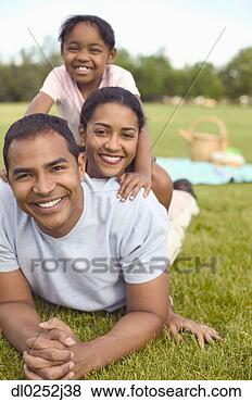Stock Photo - portrait of young 
couple and their 
child lying on 
a lawn. fotosearch 
- search stock 
photos, pictures, 
images, and photo 
clipart