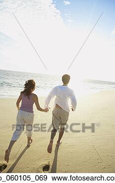 Stock Photograph - couple running 
on the beach, 
los cabos, mexico. 
fotosearch - search 
stock photos, 
pictures, images, 
and photo clipart