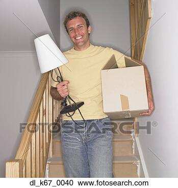 Stock Photography - man carrying lamp 
and box down stairs 
in new house. 
fotosearch - search 
stock photos, 
pictures, images, 
and photo clipart