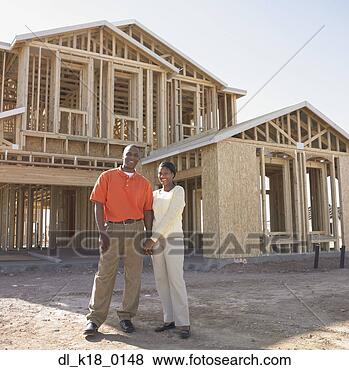 Stock Photo - portrait of a 
mid adult couple 
standing in front 
of a wooden house. 
fotosearch - search 
stock photos, 
pictures, images, 
and photo clipart