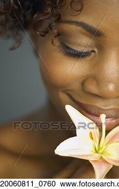 Stock Photography - close up of african 
woman smelling 
flower. fotosearch 
- search stock 
photos, pictures, 
images, and photo 
clipart