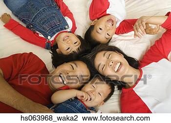 Stock Photo - high angle view 
of asian family 
laying on bed. 
fotosearch - search 
stock photos, 
pictures, images, 
and photo clipart
