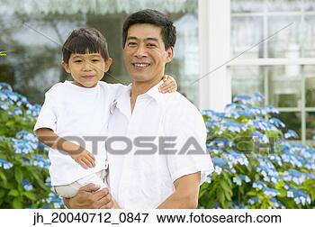 Picture - mid adult man 
standing holding 
a young boy. fotosearch 
- search stock 
photos, pictures, 
images, and photo 
clipart