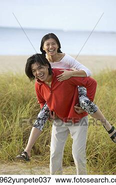 Picture - young woman riding 
piggyback on a 
young man. fotosearch 
- search stock 
photos, pictures, 
images, and photo 
clipart