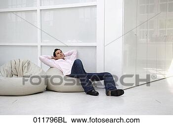 Stock Photo - young man day-dreaming 
on bean bag. fotosearch 
- search stock 
photos, pictures, 
images, and photo 
clipart