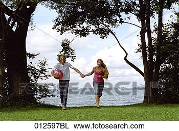 Stock Photo - young couple running 
hand in hand. 
fotosearch - search 
stock photos, 
pictures, images, 
and photo clipart