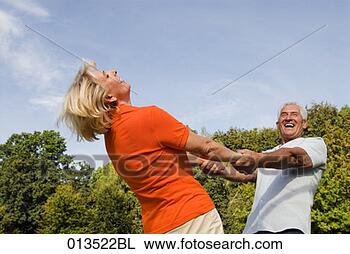 Stock Photo - mature couple 
joyfully dancing 
in park. fotosearch 
- search stock 
photos, pictures, 
images, and photo 
clipart