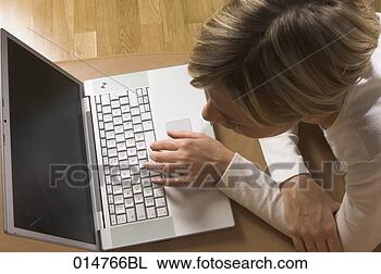 Stock Photo - high angle view 
of young woman 
lying on the floor 
working with laptop. 
fotosearch - search 
stock photos, 
pictures, images, 
and photo clipart