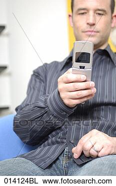 Stock Photo - portrait of young 
man checking his 
mobile phone for 
text messages. 
fotosearch - search 
stock photos, 
pictures, images, 
and photo clipart
