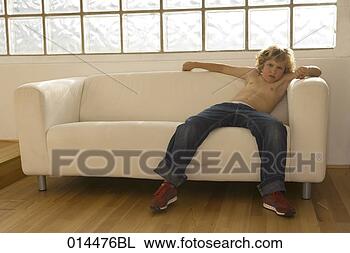 Stock Photo - sulky young boy 
sitting on sofa. 
fotosearch - search 
stock photos, 
pictures, images, 
and photo clipart