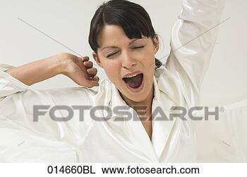 Stock Photo - woman in white 
pajamas yawning 
in her bed in 
the morning. fotosearch 
- search stock 
photos, pictures, 
images, and photo 
clipart