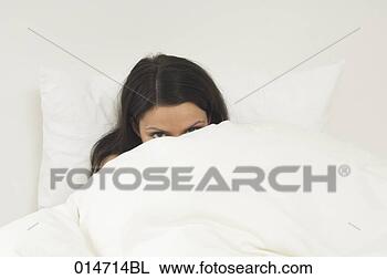 Stock Photo - young woman hiding 
in bed behind 
duvet. fotosearch 
- search stock 
photos, pictures, 
images, and photo 
clipart