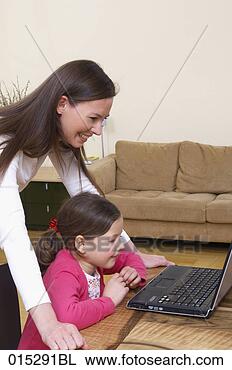Stock Photo - young mother showing 
little daughter 
how to work with 
laptop computer. 
fotosearch - search 
stock photos, 
pictures, images, 
and photo clipart