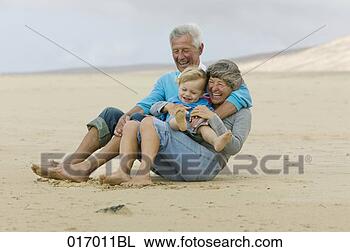 Stock Photo - grandparents and 
toddler having 
fun on beach. 
fotosearch - search 
stock photos, 
pictures, images, 
and photo clipart