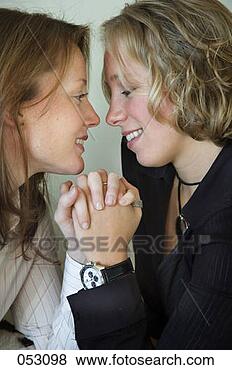 Stock Photo - holding_hands, 
looking at each 
other, adults, 
couples, women. 
fotosearch - search 
stock photos, 
pictures, images, 
and photo clipart