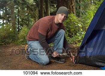 Stock Photo - a man hammering 
in a tent peg. 
fotosearch - search 
stock photos, 
pictures, images, 
and photo clipart