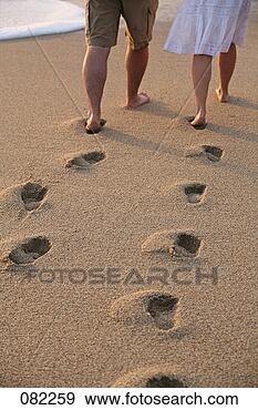 Stock Photograph - a man and woman 
leave footprints 
behind in the 
sand as they walk. 
fotosearch - search 
stock photos, 
pictures, images, 
and photo clipart