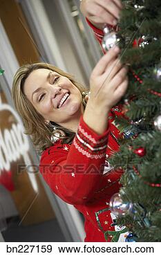 Stock Photograph - businesswoman 
putting ornament 
on christmas tree. 
fotosearch - search 
stock photos, 
pictures, images, 
and photo clipart