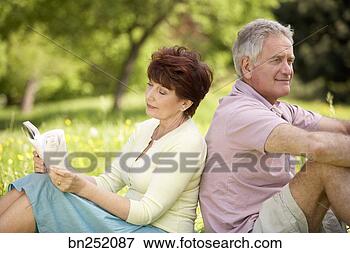 Picture - couple relaxing 
in field. fotosearch 
- search stock 
photos, pictures, 
images, and photo 
clipart