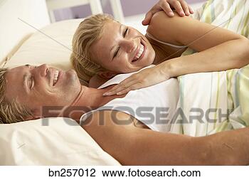 Stock Photo - smiling couple 
cuddling in bed. 
fotosearch - search 
stock photos, 
pictures, images, 
and photo clipart