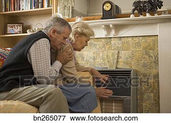 Picture - couple sitting 
by heater. fotosearch 
- search stock 
photos, pictures, 
images, and photo 
clipart