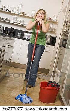 Picture - woman daydreaming 
while mopping. 
fotosearch - search 
stock photos, 
pictures, images, 
and photo clipart