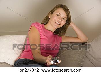 Stock Photo - woman using television 
remote. fotosearch 
- search stock 
photos, pictures, 
images, and photo 
clipart