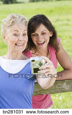 Stock Photography - mother and daughter 
taking picture. 
fotosearch - search 
stock photos, 
pictures, images, 
and photo clipart