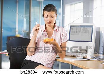 Stock Photography - office worker 
eating at desk. 
fotosearch - search 
stock photos, 
pictures, images, 
and photo clipart