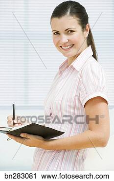 Stock Photography - woman writing 
in day planner. 
fotosearch - search 
stock photos, 
pictures, images, 
and photo clipart