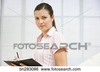 Stock Photo - woman writing 
in day planner. 
fotosearch - search 
stock photos, 
pictures, images, 
and photo clipart