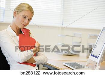 Stock Photo - businesswoman 
hugging heating 
pad at desk. fotosearch 
- search stock 
photos, pictures, 
images, and photo 
clipart