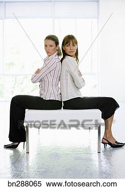 Stock Image - businesswomen  sitting back to  back. fotosearch  - search stock  photos, pictures,  images, and photo  clipart