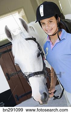 Stock Photograph - smiling girl wearing 
horse riding helmet 
by horse. fotosearch 
- search stock 
photos, pictures, 
images, and photo 
clipart