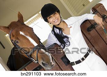 Stock Photo - smiling woman 
wearing horse 
riding helmet 
by horse. fotosearch 
- search stock 
photos, pictures, 
images, and photo 
clipart
