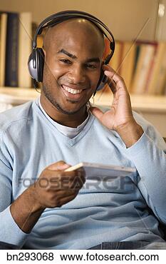 Stock Photo - man wearing headphones 
and holding cd 
case. fotosearch 
- search stock 
photos, pictures, 
images, and photo 
clipart