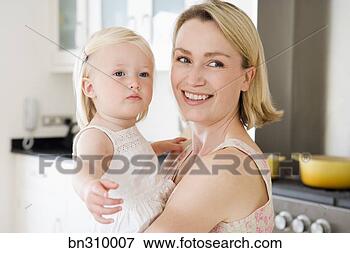 Foto - mãe,  segurando, 
 criança,  cozinha. 
fotosearch - busca 
de fotos, imagens 
e clipart