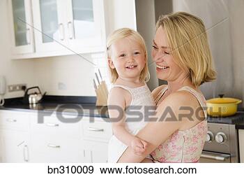Arquivo Fotográficos - mãe,  segurando, 
 criança,  cozinha. 
fotosearch - busca 
de fotos, imagens 
e clipart