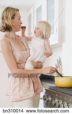Banco de Imagem - mãe,  segurando, 
 criança,  fazer, 
 alimento,  cozinha. 
fotosearch - busca 
de fotos, imagens 
e clipart